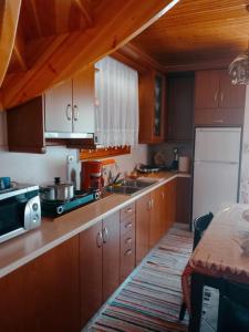 a kitchen with wooden cabinets and a white refrigerator at Maroulas House in Chrysomiléa