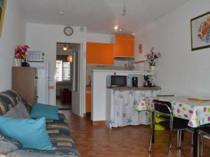 eine Küche und ein Wohnzimmer mit einem Sofa und einem Tisch in der Unterkunft Appartement Le Grau-du-Roi, 2 pièces, 4 personnes - FR-1-250-136 in Le Grau-du-Roi