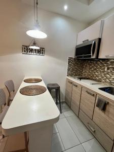 a kitchen with a white counter top and a table at Walk to the Beach 2Min, Cozy, Boutique, Pool, Palmeras Del Mar Isabela in Isabela