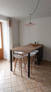 una mesa de madera y sillas en una habitación en Chez Marie, en Albaret-Sainte-Marie
