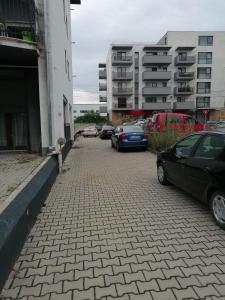a group of cars parked on a brick street at Queency Apartament cu gradina și parcare gratuita in Cluj-Napoca