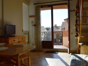 uma sala de estar com uma mesa e uma porta de vidro deslizante em Appartement Saint-Cyprien, 2 pièces, 6 personnes - FR-1-225D-25 em Saint-Cyprien-Plage