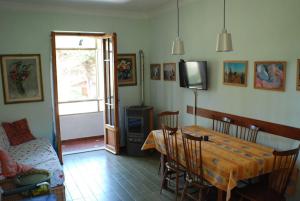 a living room with a dining room table and a tv at Giannella Apartment in Orbetello
