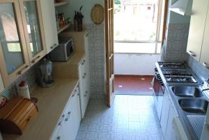 a small kitchen with a stove and a window at Giannella Apartment in Orbetello
