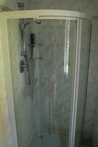 a shower with a glass door in a bathroom at Giannella Apartment in Orbetello
