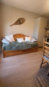 1 dormitorio con cama de madera y almohadas en Cozy Appartement avec vue sur montagne, en Bourisp
