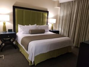 a large bed in a hotel room with two lamps at VACATION VILLAGE PARKWAY - KISSIMMEE,FL 34747 in Orlando