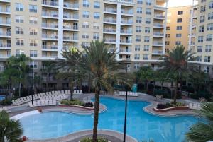 une piscine en face d'un grand immeuble dans l'établissement VACATION VILLAGE PARKWAY - KISSIMMEE,FL 34747, à Orlando