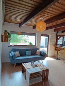 ein Wohnzimmer mit einem blauen Sofa und einem Tisch in der Unterkunft Ferienhaus, Ferienwohnung Heimathafen, zentral in Überherrn in Überherrn