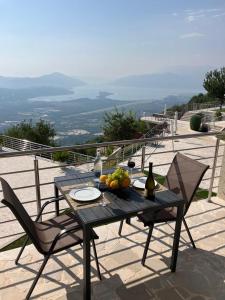 een tafel met een fruitschaal en een fles wijn bij Villa Eagle Eye Montenegro in Kotor