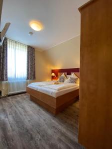 um quarto com uma cama grande e uma janela em Buten-Diek em Dornumersiel