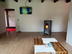 a room with a fireplace with a table and a tv at Heimathafen, eingezäunter großer Garten - zentral in Überherrn - Parkplatz - Wifi - Grill in Überherrn