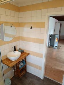 a bathroom with a sink and a mirror and a television at Ferienhaus, Ferienwohnung Heimathafen, zentral in Überherrn in Überherrn