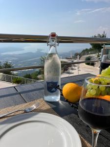 a glass of wine and a plate of fruit on a table at Villa Eagle Eye Montenegro in Kotor