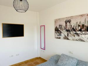 a living room with a couch and a tv on a wall at VillaMar in Villaverde