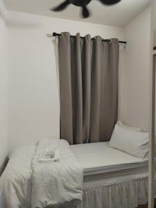 a bed in a bedroom with a ceiling fan at Geo Condo Homestay Kota Kemuning Bukit Rimau in Shah Alam +8 photos