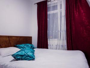 1 dormitorio con 1 cama y una ventana con cortinas rojas en Greenzone Luxury 1 Bed Apartment, en Nairobi