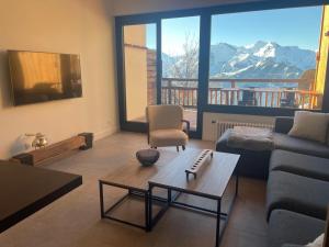 a living room with a couch and a table at Très bel appart avec vue 8 personnes Alpe d’Huez in LʼHuez