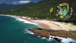 a beach with a kite flying over the ocean at Pousada Encontro das Águas in Trindade