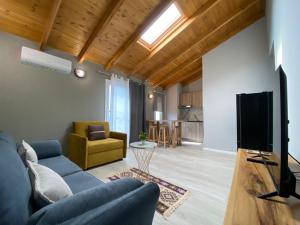 a living room with a blue couch and a tv at Villa Yseni in Orikum
