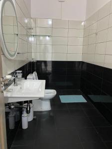 W łazience znajduje się umywalka, lustro i toaleta. w obiekcie Villa Yseni w mieście Orikum