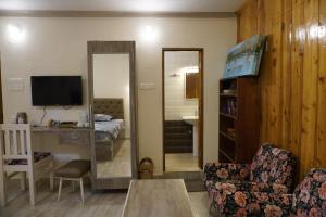 ein Wohnzimmer mit einem TV und einem Spiegel in der Unterkunft Farsal Villa in Srinagar