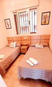 2 camas en una habitación pequeña con ventana en apartamento Oropesa del mar- Marina D'Or- Magic World, en Oropesa del Mar