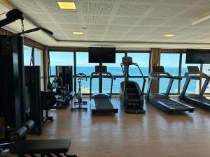 um ginásio com várias passadeiras e equipamento de exercício e janelas em Salvador barra em Salvador