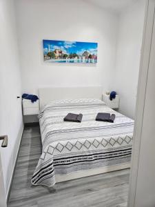 uma cama num quarto branco com uma fotografia na parede em Chalet Luxury with privacy and Jacuzzi em Maspalomas