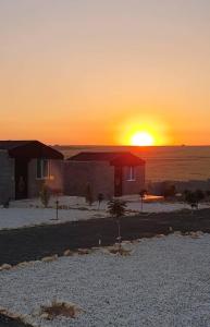 a house in the desert with the sunset in the background at Dana Sunset Eco Camp in Dana