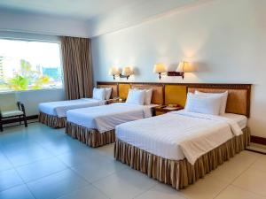 pokój hotelowy z 2 łóżkami i oknem w obiekcie Hotel Sor w mieście Phnom Penh