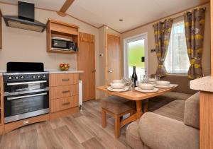 a kitchen and living room with a table and a couch at B12, Tal y Fan in Abersoch