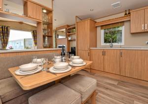 a kitchen with a wooden table with dishes on it at B12, Tal y Fan in Abersoch