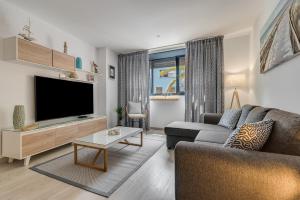 un soggiorno con divano e TV a schermo piatto di ANIDRAS Rooms a Sardina