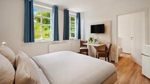 a hotel room with a bed and a table at Hotel Deichinsel in Wangerland