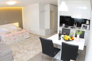 a kitchen and living room with a table and chairs at Studio Apartments Mirakul in Split