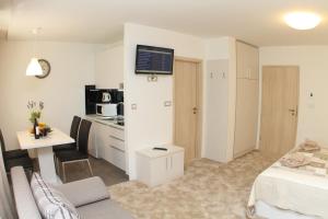 a room with a bed and a desk and a kitchen at Studio Apartments Mirakul in Split