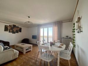 sala de estar con mesa blanca y sillas en Le Buffel - Appartement 4 chambres, Parking, Wi-fi, Tram - 8pers, en Montpellier