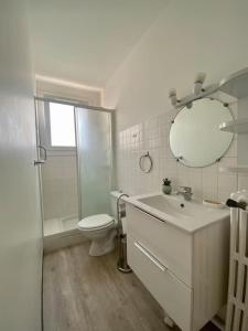y baño con lavabo, aseo y espejo. en Le Buffel - Appartement 4 chambres, Parking, Wi-fi, Tram - 8pers, en Montpellier