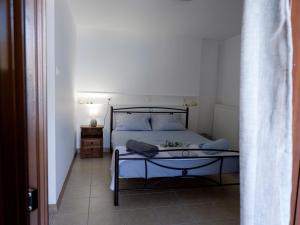 sypialnia z łóżkiem i podłogą wyłożoną kafelkami w obiekcie Mani home w mieście Neo Itilo