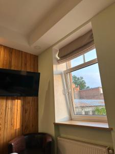 een kamer met een raam met een stoel en een televisie bij ApartmentTallinas70B in Rīga