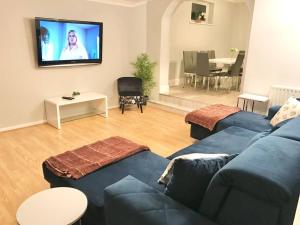 uma sala de estar com um sofá azul e uma televisão em Dolphin Retreat close to Beaches and Harbour em Poole