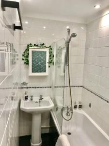 uma casa de banho branca com um lavatório e um chuveiro em Dolphin Retreat close to Beaches and Harbour em Poole