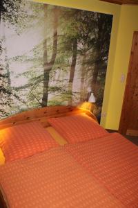 ein Schlafzimmer mit einem Wandbild von Bäumen in der Unterkunft Haus Seefeld in Ückeritz