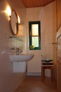 een badkamer met een wastafel, een spiegel en een raam bij Haus Seefeld in Ueckeritz