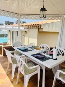 プラヤ・デル・イングレスにあるTownhouse El Marの白いダイニングテーブルと椅子付きのパティオ
