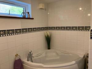 een badkamer met een wit bad en een raam bij Walnut Cottage in Newton Ferrers