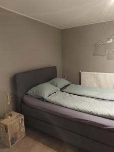 a bedroom with a bed and a nightstand with a box at B&Bie Ons appartement in Bad-Nieuweschans
