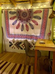 una mesa y una silla en una habitación con una manta en Wallpari Sonqo Hospedaje Medicina temazcal en Pisac