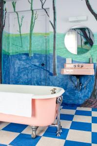 a bathroom with a bath tub and a mural of trees at The Waldoboro Inn Room 5 in Waldoboro